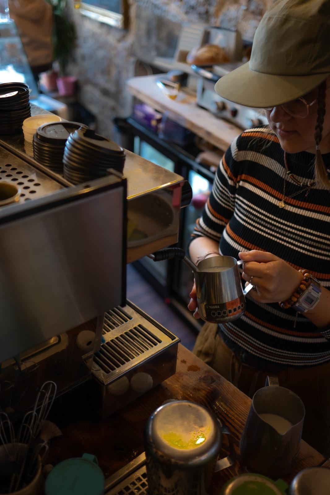 Barista steaming milk at Books N' Cup Tollcross